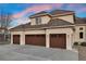 Three-car garage with dark brown doors and exterior lights at 16394 W 77Th Ln, Arvada, CO 80007