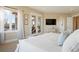 Spacious main bedroom with a large window, private balcony, and TV at 16394 W 77Th Ln, Arvada, CO 80007
