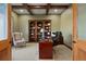 Home office with built-in bookshelves, wood desk, and comfortable seating at 16394 W 77Th Ln, Arvada, CO 80007