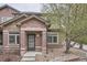 Charming brick front entrance with a black front door and well maintained landscaping at 6506 Silver Mesa Dr # F, Highlands Ranch, CO 80130