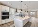 Modern kitchen with white cabinets, island, and stainless steel appliances at 9656 Browns Peak Cir, Littleton, CO 80125