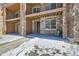 Townhome entrance with stone exterior, private balcony, and snowy landscaping at 9656 Browns Peak Cir, Littleton, CO 80125