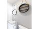 Charming bathroom featuring round mirror, wall shelves, and toilet at 9925 W 20Th Ave # 2, Lakewood, CO 80215