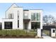 Modern home boasts a bright white facade, sleek black framed windows, and stylish minimalist landscaping at 1001 S Adams St, Denver, CO 80209