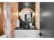 Chic powder room with patterned wallpaper, a round mirror, and a sleek black vanity at 1001 S Adams St, Denver, CO 80209