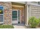 Close-up of front door with stone facade, and well-manicured bushes at 4385 S Balsam St # 6-103, Littleton, CO 80123