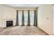 A bright and airy living room features a fireplace, large windows, and neutral carpet at 4385 S Balsam St # 6-103, Littleton, CO 80123
