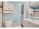 Cozy bathroom featuring blue walls, white cabinets and a mirrored vanity at 13504 E Asbury Dr, Aurora, CO 80014