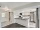 Modern kitchen featuring white cabinets, a breakfast bar, black countertops and stainless steel appliances at 13504 E Asbury Dr, Aurora, CO 80014