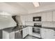 Well-equipped kitchen featuring white cabinets, black countertops, and stainless steel appliances at 13504 E Asbury Dr, Aurora, CO 80014