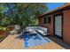 Back deck boasts an outdoor seating area with brick home backdrop, plus natural shade from trees at 15 Pawnee Dr, Boulder, CO 80303