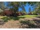 Large, grassy backyard featuring a deck, a brick house, and wood fencing with mature trees and blue skies at 15 Pawnee Dr, Boulder, CO 80303