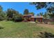 Backyard features lush lawn, trees, large back deck, and brick home with fenced area at 15 Pawnee Dr, Boulder, CO 80303