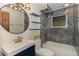 Bathroom featuring stylish round mirror, blue shelving, and tiled shower and tub combo at 15 Pawnee Dr, Boulder, CO 80303