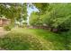 Large, well-kept backyard featuring a lush green lawn, wooden fence, mature trees, and ample space at 20738 E Grand Pl, Aurora, CO 80015