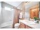 Bathroom featuring a shower-tub combo, white tile, and vanity with a sink and wooden cabinets at 20738 E Grand Pl, Aurora, CO 80015