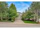 Charming two-story home surrounded by lush trees, showcasing a spacious driveway and well-maintained lawn at 20738 E Grand Pl, Aurora, CO 80015