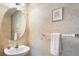 Neutral-toned powder room with a pedestal sink and a decorative mirror at 20738 E Grand Pl, Aurora, CO 80015