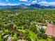 An aerial view highlights the neighborhood, showcasing mature trees, open spaces, and mountain views at 5530 Racquet Ln, Boulder, CO 80303