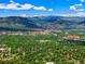 The scenic aerial view captures the mountain range overlooking a lush, green neighborhood at 5530 Racquet Ln, Boulder, CO 80303