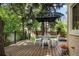 Beautiful back deck features a table and chairs under the shade of mature trees at 5530 Racquet Ln, Boulder, CO 80303