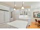 Bright kitchen featuring a center island, white cabinets, stainless steel appliances, and hardwood flooring at 5530 Racquet Ln, Boulder, CO 80303