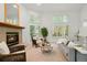 Cozy living room featuring a fireplace, ample seating, and natural light from large windows, ideal for relaxation and entertaining at 5530 Racquet Ln, Boulder, CO 80303