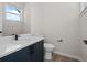 Bathroom with navy blue vanity, white countertop and toilet at 7066 W 13Th Ave, Lakewood, CO 80214