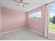Light-filled bedroom featuring plush carpeting, soft pink walls, and a scenic window view at 7066 W 13Th Ave, Lakewood, CO 80214