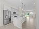 Modern kitchen features white cabinets, a stainless steel refrigerator, and an island with pendant lighting at 7066 W 13Th Ave, Lakewood, CO 80214