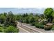 Scenic street view with railroad tracks, lush trees, and mountains in the distance, creating a serene environment at 7066 W 13Th Ave, Lakewood, CO 80214
