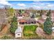 Aerial view showcasing a charming home, manicured lawn, mature trees and solar panels at 7100 W Ellsworth Pl, Lakewood, CO 80226