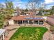 Aerial view of home featuring a backyard with covered patio, solar panels, and a well-manicured lawn at 7100 W Ellsworth Pl, Lakewood, CO 80226