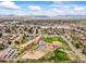 Aerial view of neighborhood, showcasing a school, park, and tree-lined streets with mountain views at 7100 W Ellsworth Pl, Lakewood, CO 80226