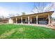 Spacious backyard with covered patio, lush lawn, and hot tub, perfect for outdoor enjoyment at 7100 W Ellsworth Pl, Lakewood, CO 80226