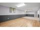 Finished basement features paneling, carpet, vinyl flooring, and window with curtains at 7100 W Ellsworth Pl, Lakewood, CO 80226