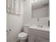 Bathroom featuring a single sink vanity, toilet, mirror, and storage, offering functionality and style at 7100 W Ellsworth Pl, Lakewood, CO 80226