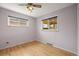 Cozy bedroom with hardwood floors, ceiling fan with lighting, and large windows for natural light at 7100 W Ellsworth Pl, Lakewood, CO 80226