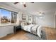 Well-lit bedroom with hardwood floors, a ceiling fan, two windows, and neutral décor at 7100 W Ellsworth Pl, Lakewood, CO 80226