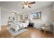 Bright bedroom featuring two ceiling fans, two windows, hardwood floors, and neutral décor at 7100 W Ellsworth Pl, Lakewood, CO 80226