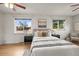 Comfortable bedroom with two large windows, ceiling fan, hardwood floors, and neutral decor at 7100 W Ellsworth Pl, Lakewood, CO 80226