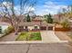 Charming ranch-style home with a well-manicured front yard, mature tree, and a two-car garage on a sunny day at 7100 W Ellsworth Pl, Lakewood, CO 80226