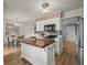 Spacious kitchen with white cabinetry, butcher block island, stainless steel appliances, and adjacent dining area at 7100 W Ellsworth Pl, Lakewood, CO 80226