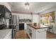 Well-lit kitchen boasting stainless steel appliances, white cabinets, granite countertops, and center island with wood countertop at 7100 W Ellsworth Pl, Lakewood, CO 80226