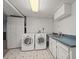 Bright laundry room with washer, dryer, utility sink, and storage cabinets at 7100 W Ellsworth Pl, Lakewood, CO 80226