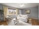 Cozy living room with hardwood floors, a comfortable sofa, and a view to the front yard through a bright window at 7100 W Ellsworth Pl, Lakewood, CO 80226