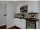 Modern bar area with a granite counter, stainless steel microwave, beverage cooler and mosaic backsplash at 8171 E 33Rd Ave, Denver, CO 80238