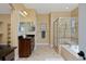 Bathroom featuring double vanity sinks, walk-in shower, and a soaking tub at 8171 E 33Rd Ave, Denver, CO 80238