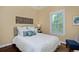 Cozy bedroom featuring a plush bed, accent pillows, modern art and natural light from the window at 8171 E 33Rd Ave, Denver, CO 80238