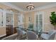 Elegant dining room has hardwood floors, neutral walls, and a modern glass table with gray seating for six at 8171 E 33Rd Ave, Denver, CO 80238